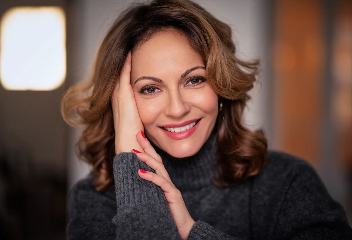 Smiling woman with refreshed natural facial appearance after deep plane facelift procedure in New York