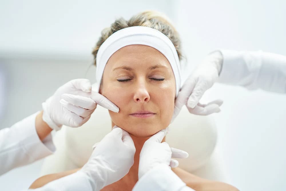 Patient receiving facial assessment and skin evaluation during cosmetic consultation for deep plane facelift treatment in New York