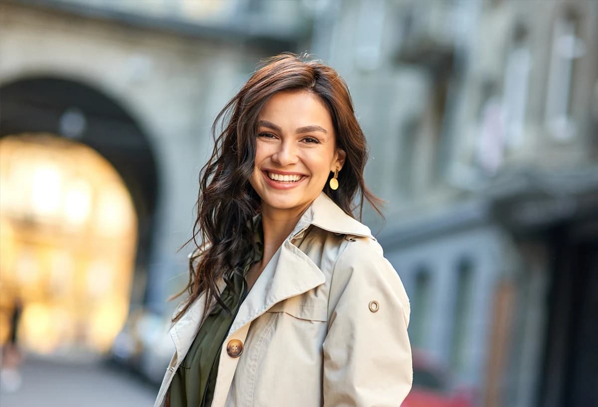 Confident smiling woman with naturally refreshed facial contours after deep plane facelift in New York City
